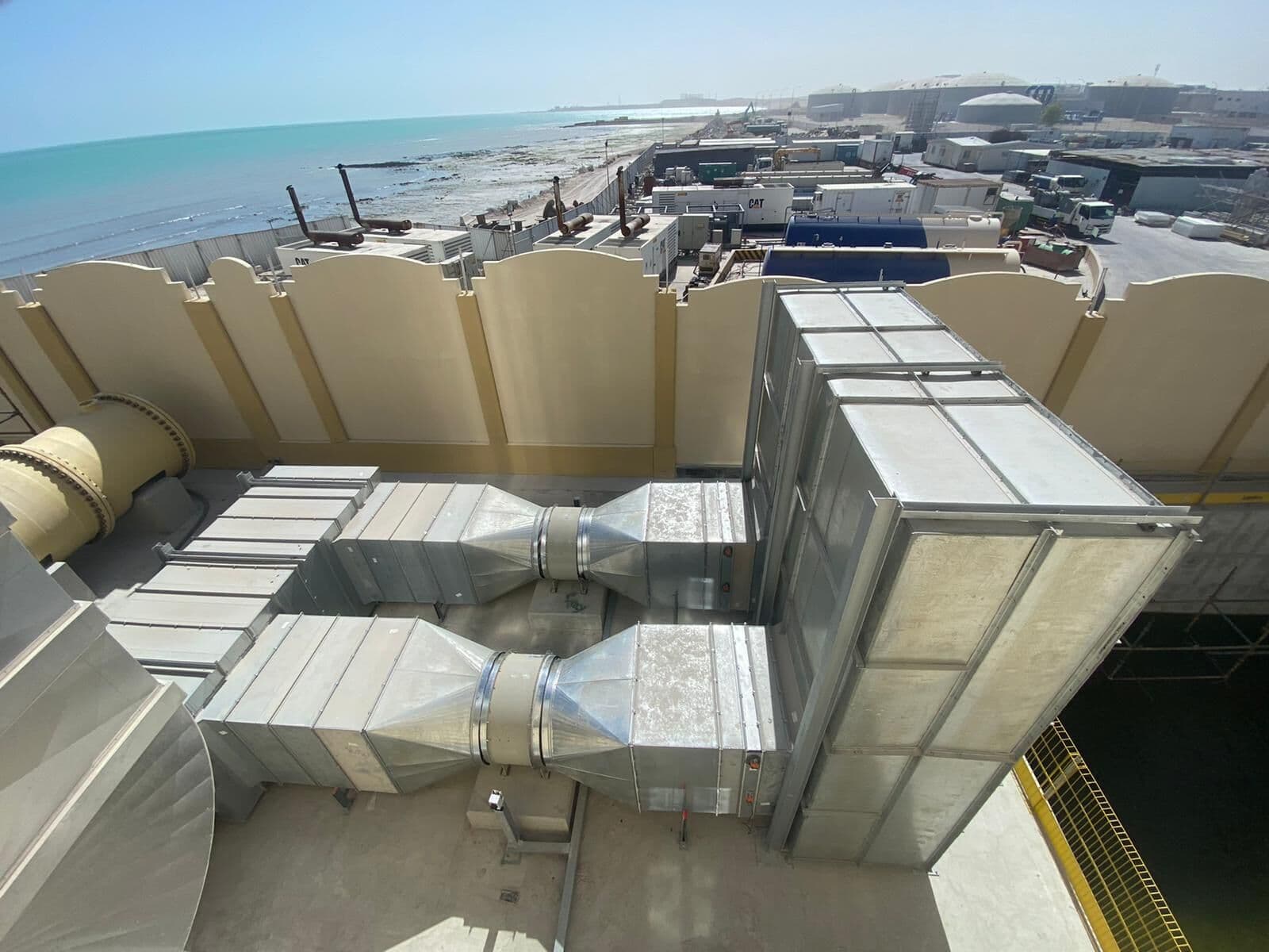 Stainless steel wet-well plenums at Musaimeer pumping station, the coast behind