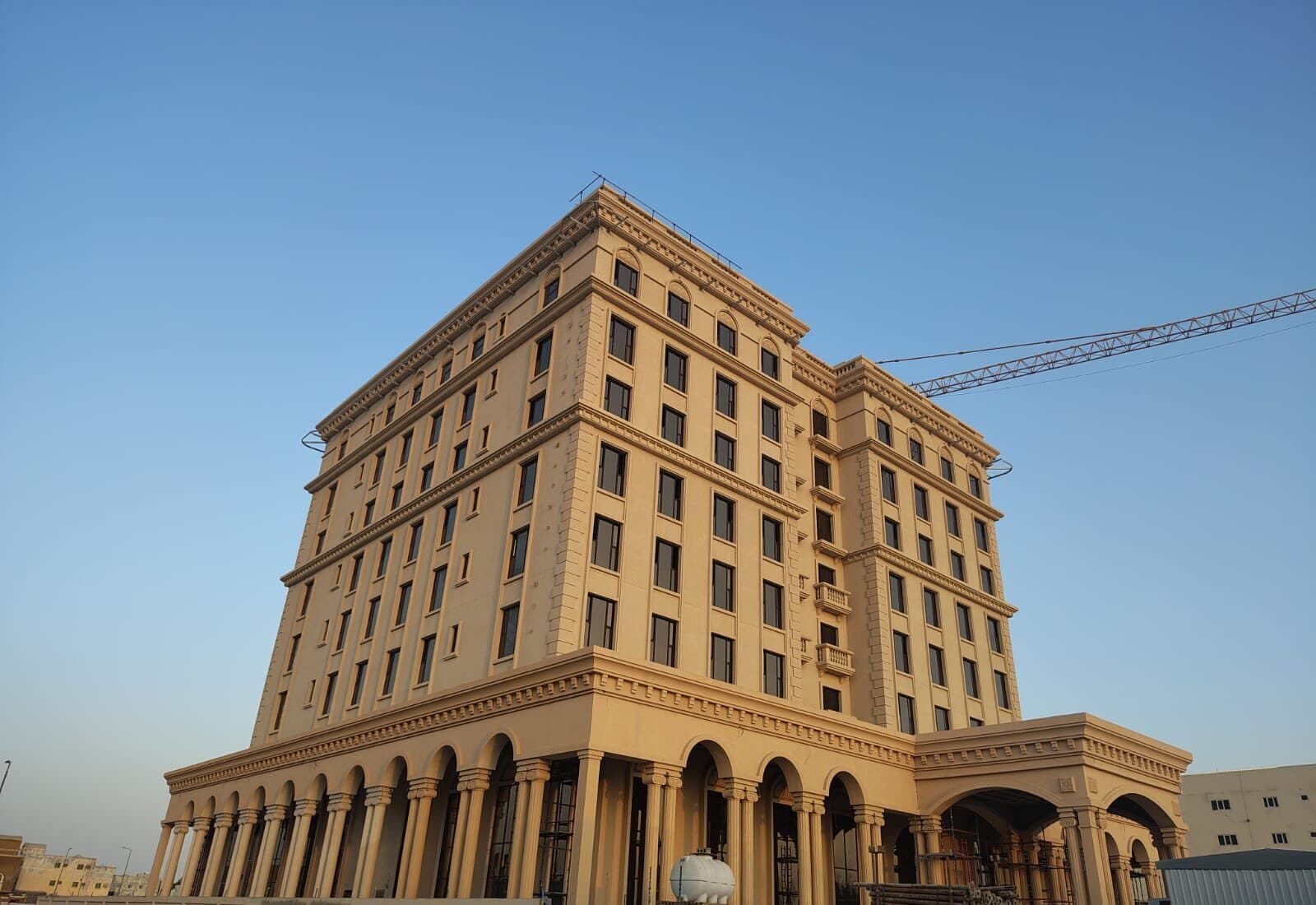 The Hilton Garden Inn, Al Hofuf, rising on site at golden hour, the tower crane above it